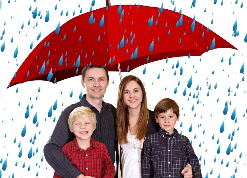 a family standing under an umbrella in the rain.