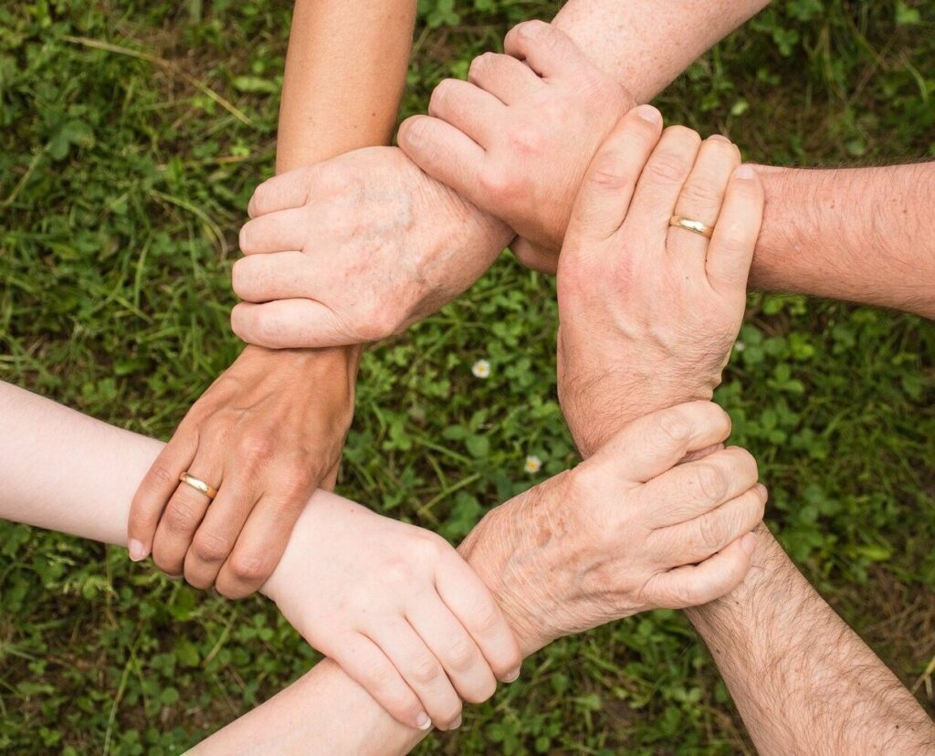 a group of people holding hands in a circle.